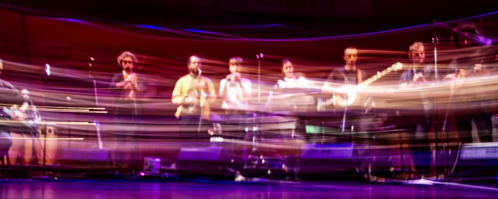 A big band with world music students on stage, the image has motion blur