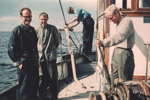 Fyra personer ombord på en äldre fiskebåt.