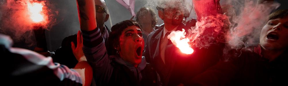 About 7 people in scene representing football hooligans with red torches. Image from the final production of the actors students play Blås av matchen (2023)