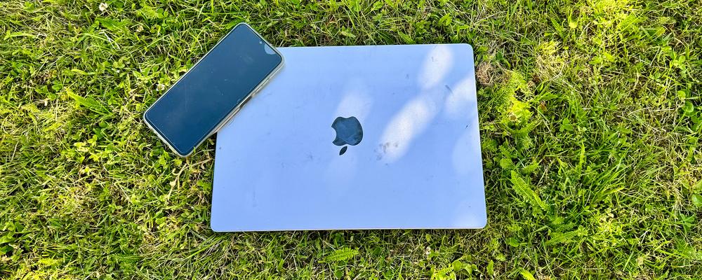Dator och mobil i gräs