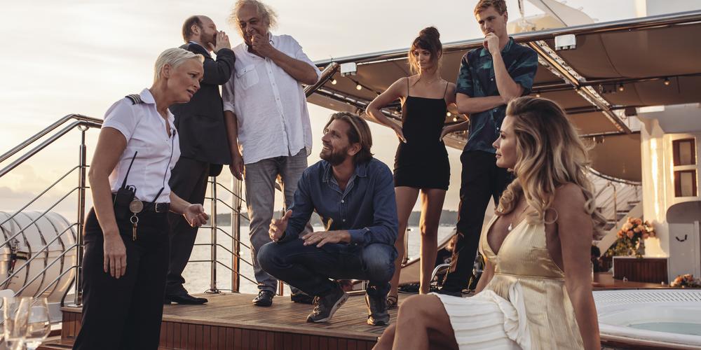 Ruben Östlund tillsammans med skådespelare från filminspelning på en båt