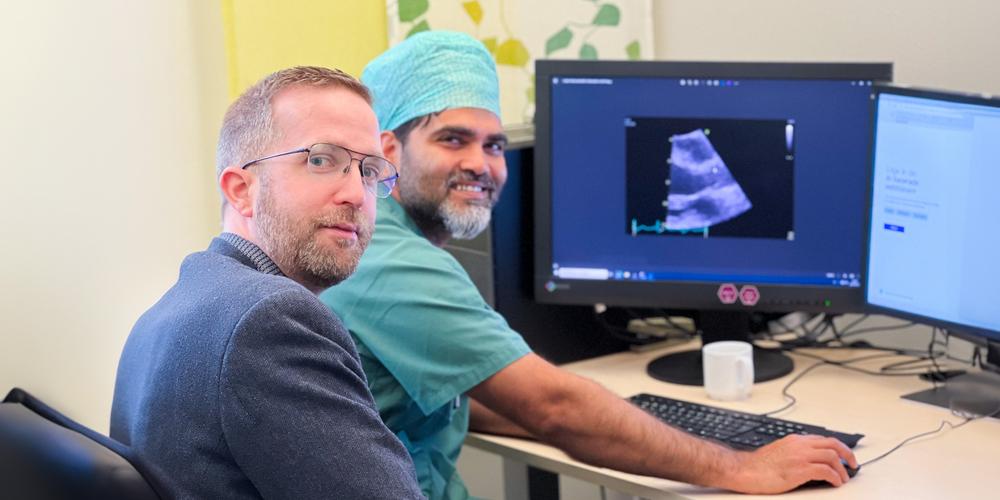 Björn and Sandeep next to each other at computer screen with ultrasound image of heart