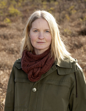 Forskaren Amelie Lindgren står utomhus i naturen. 