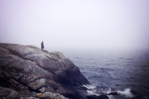regissören står på en klippa vid havet
