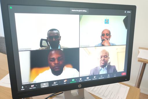 four people appearing on a screen