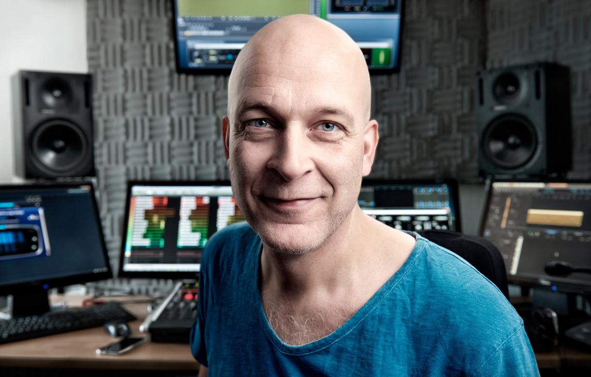 Fredrik Lidin with computers, speakers and sound production equipment in the background.